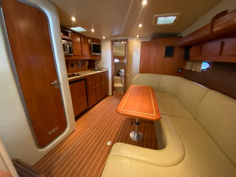 Slide: The Image of 2006 Rinker 360 Fiesta Vee interior with kitchen, seating, and wood accents. - 23