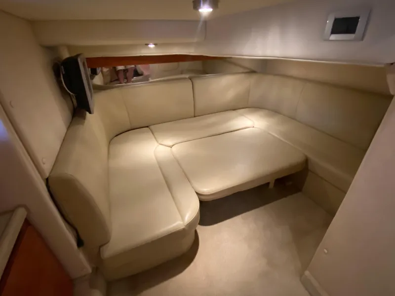 Slide: The Image of 2006 Rinker 360 Fiesta Vee interior with beige leather seating and ambient lighting. - 26