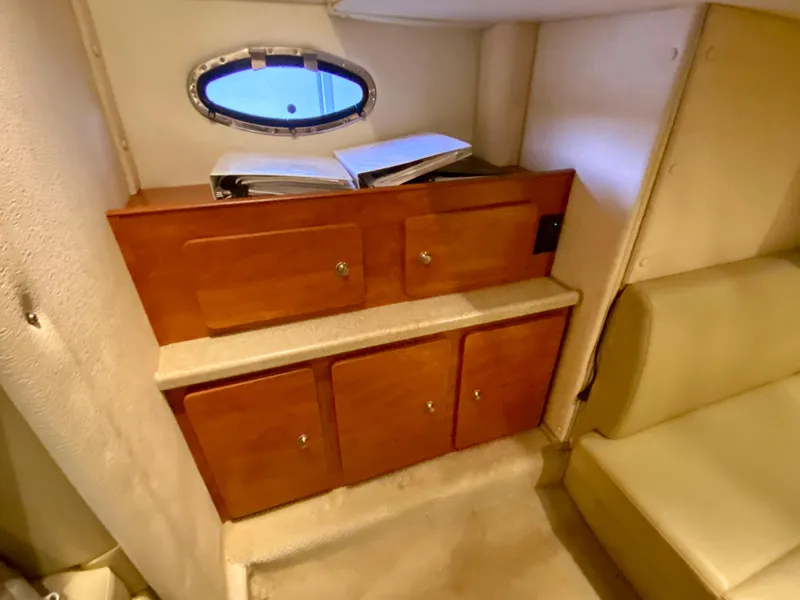 Slide: The Image of 2006 Rinker 360 Fiesta Vee cabin interior with wooden cabinets and porthole window. - 27