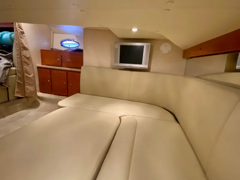 Slide: The Image of 2006 Rinker 360 Fiesta Vee cabin interior with beige seating and a small TV. - 28