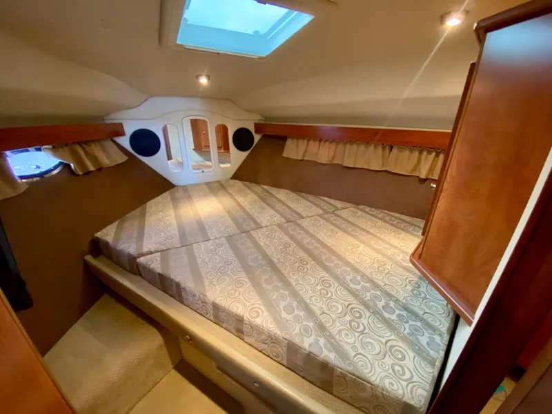 Slide: The Image of 2006 Rinker 360 Fiesta Vee cabin interior with bed, skylight, and wood accents. - 30