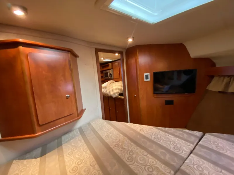 Slide: The Image of Interior of 2006 Rinker 360 Fiesta Vee boat with wood cabinetry and TV. - 31