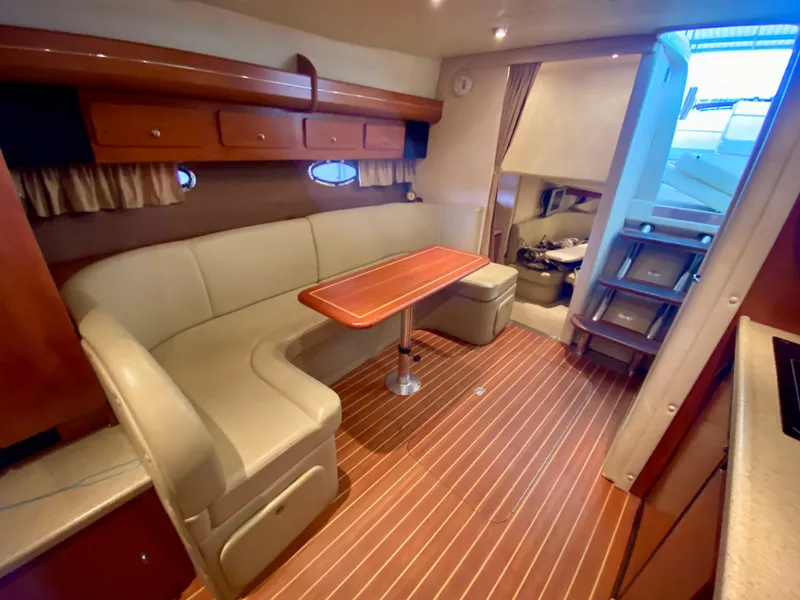 Slide: The Image of 2006 Rinker 360 Fiesta Vee interior with wood flooring, curved seating, and dining table. - 32