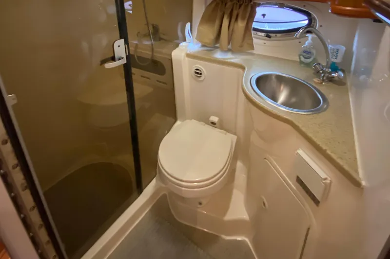 Slide: The Image of 2006 Rinker 360 Fiesta Vee bathroom with shower, toilet, sink, and porthole window. - 33