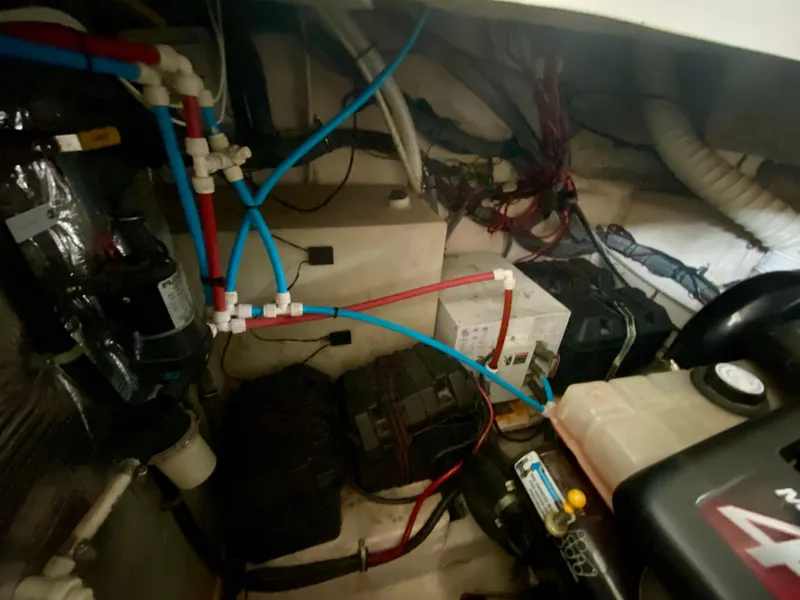 Slide: The Image of Engine compartment of a 2006 Rinker 360 Fiesta Vee with wiring and plumbing. - 40