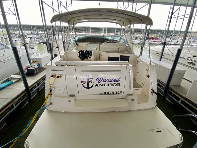 Slide: The Image of 2006 Rinker 360 Fiesta Vee boat docked, rear view with "Divine Anchor" signage. - 5