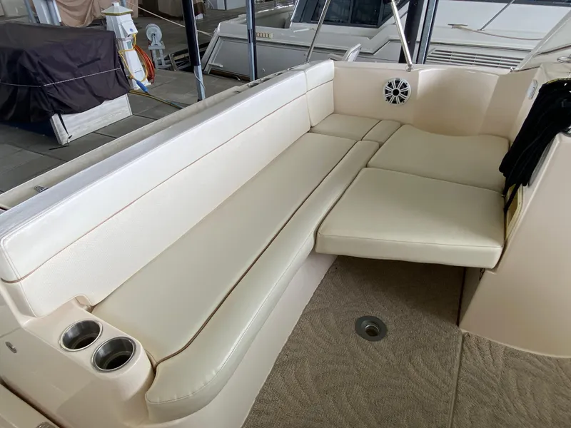 Slide: The Image of 2006 Rinker 360 Fiesta Vee boat interior with beige seating and cup holders. - 8