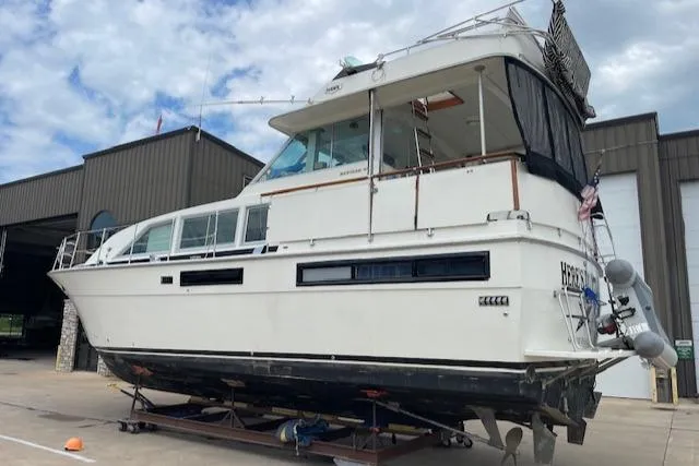 Slide: The Image of 1977 Bertram 42 Motor Yacht on dry dock, exterior view with clear sky background. - 1