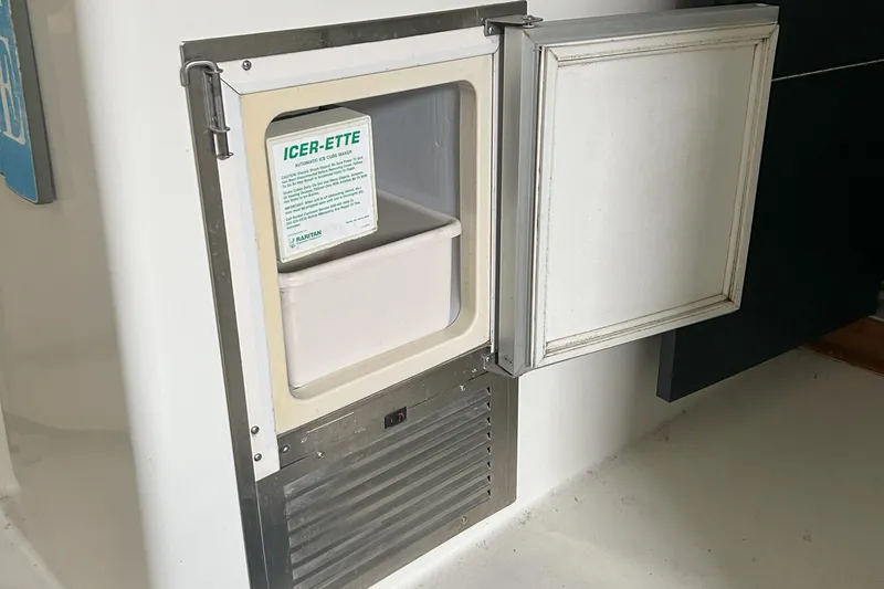 Slide: The Image of Ice maker on a 1977 Bertram 42 Motor Yacht, featuring an open door and visible ice compartment. - 21