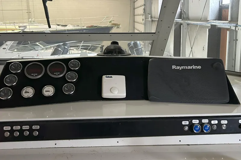 Slide: The Image of 1977 Bertram 42 Motor Yacht dashboard with gauges and Raymarine equipment. - 27