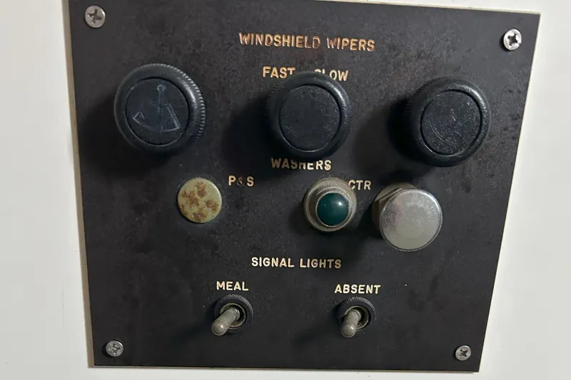 Slide: The Image of Control panel of a 1977 Bertram 42 Motor Yacht with switches and knobs. - 33