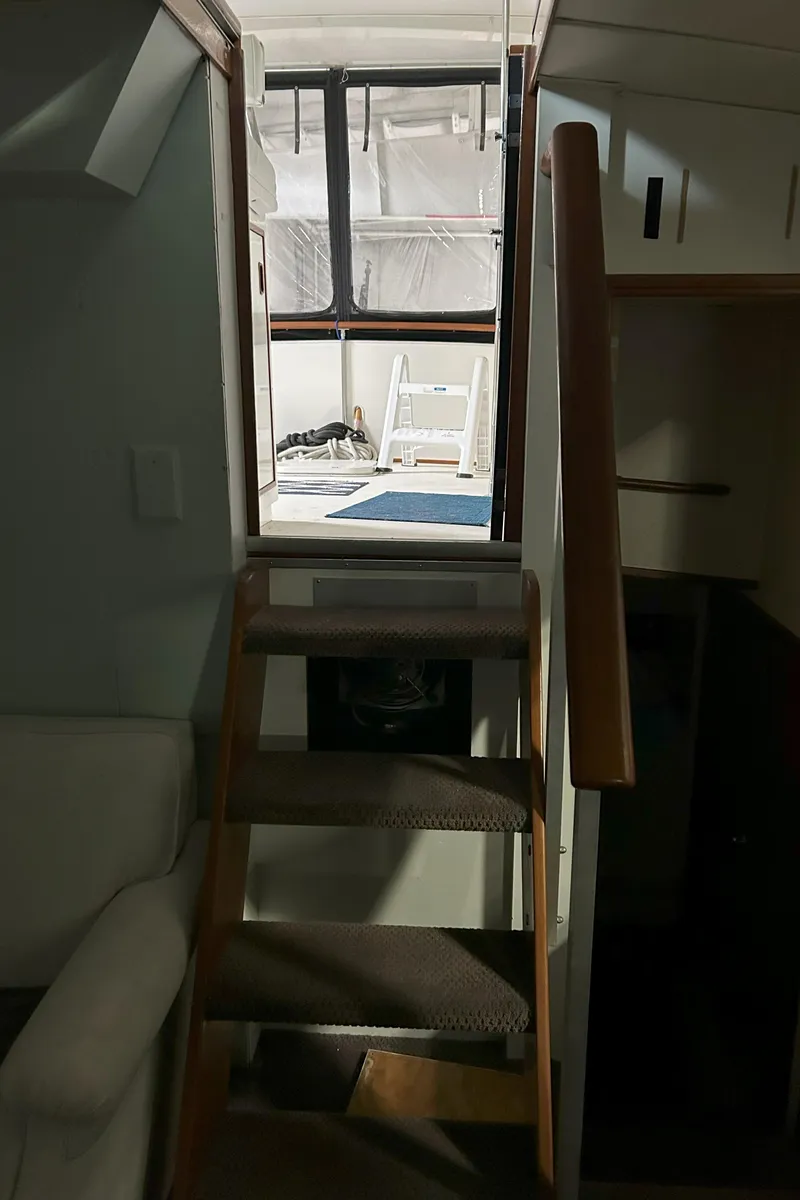 Slide: The Image of Interior view of 1977 Bertram 42 Motor Yacht, featuring wooden stairs and cabin access. - 35