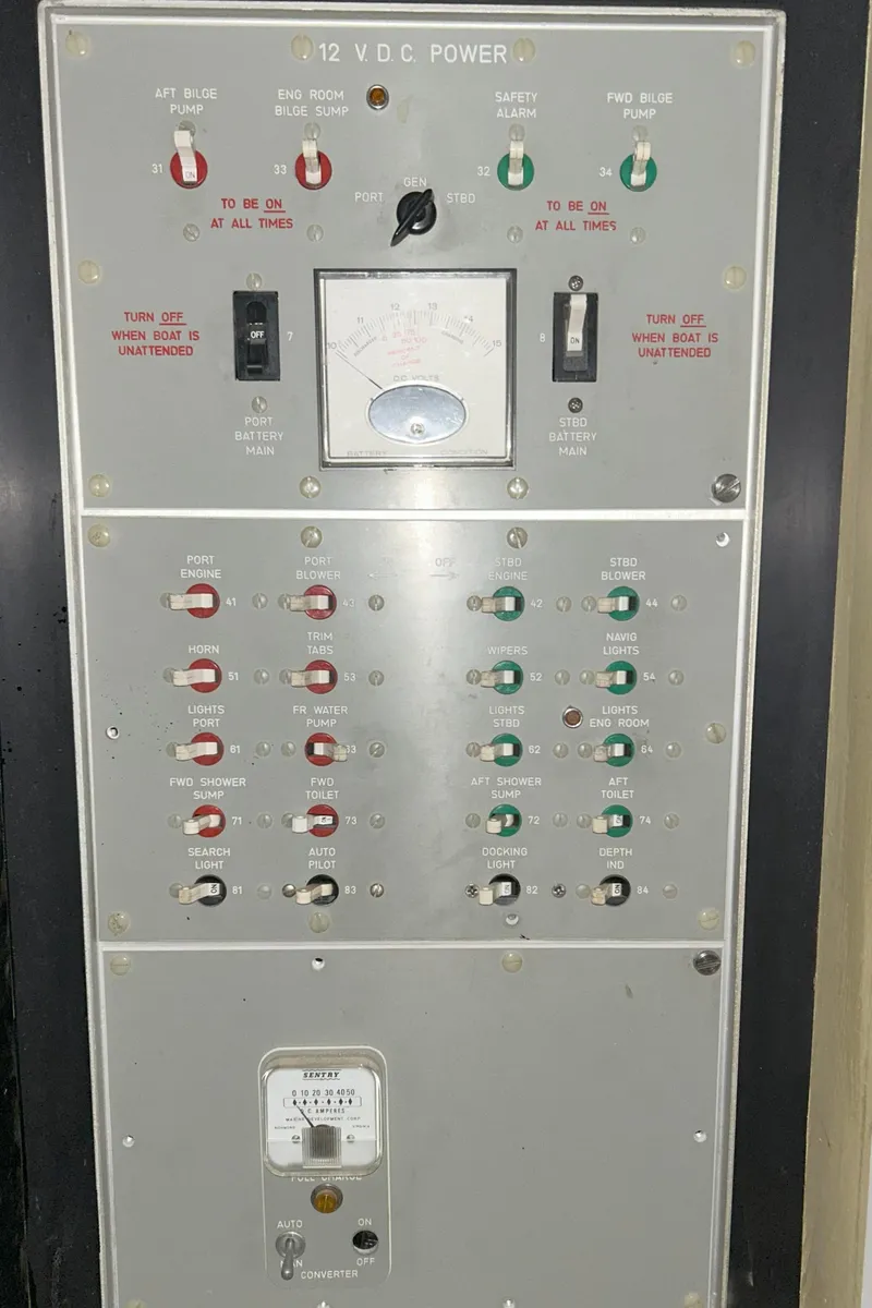 Slide: The Image of Control panel of a 1977 Bertram 42 Motor Yacht, featuring switches and indicators. - 39