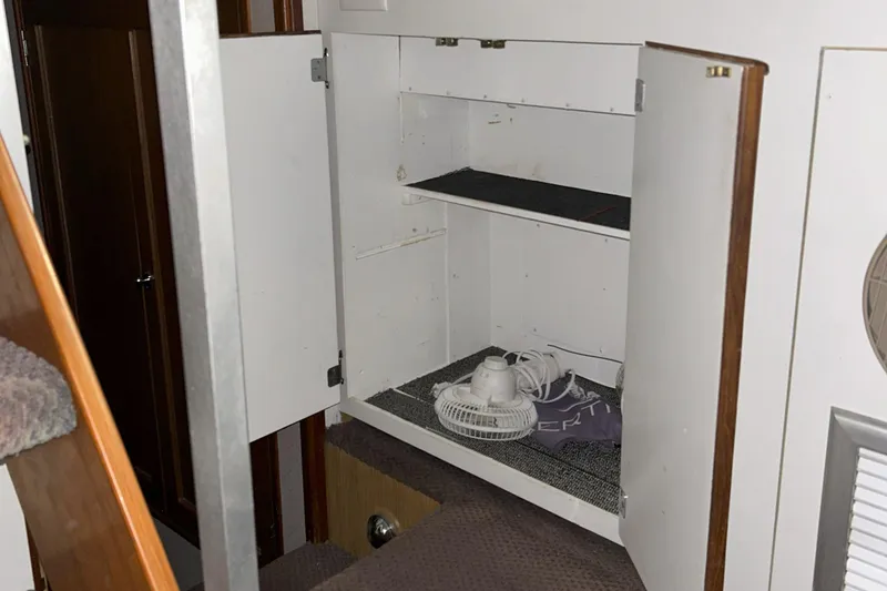 Slide: The Image of 1977 Bertram 42 Motor Yacht interior storage with open cabinet and small fan. - 41