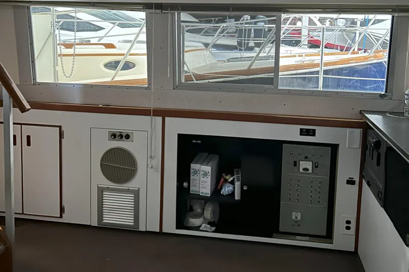 Slide: The Image of Interior of a 1977 Bertram 42 Motor Yacht with docked boats visible through windows. - 42