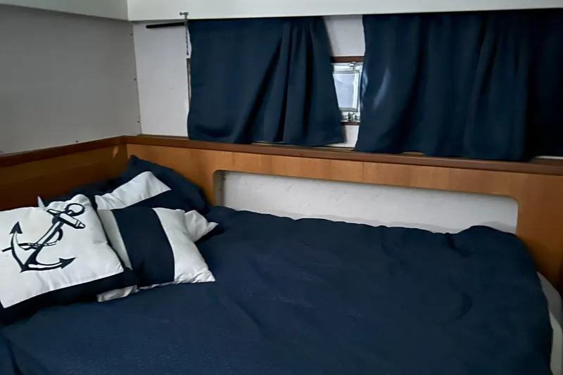 Slide: The Image of Cozy cabin interior of 1977 Bertram 42 Motor Yacht with nautical-themed bedding. - 44