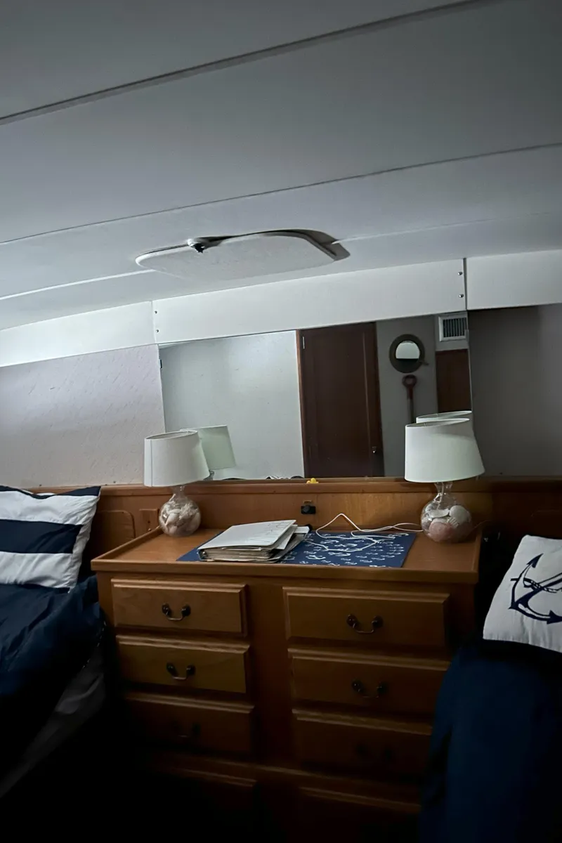 Slide: The Image of Interior of 1977 Bertram 42 Motor Yacht with wooden dresser and nautical decor. - 45