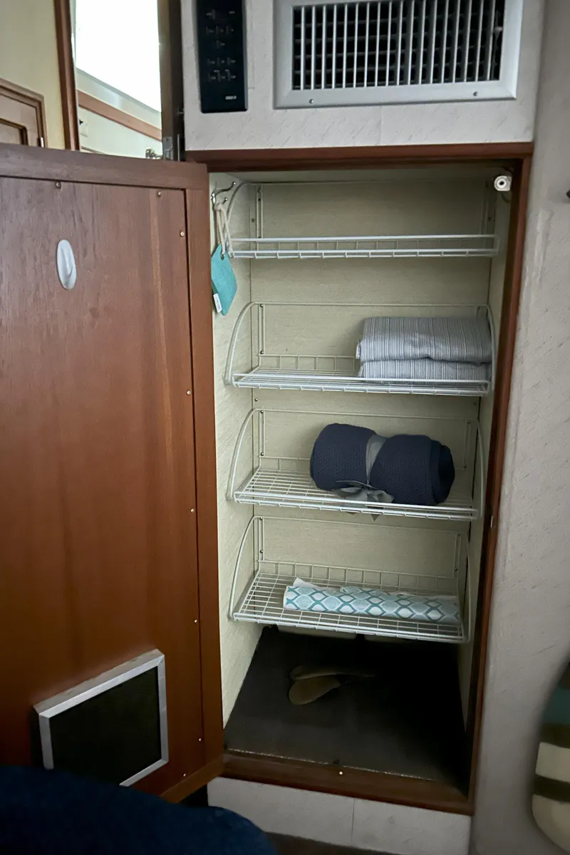Slide: The Image of 1977 Bertram 42 Motor Yacht interior storage with wire shelves and folded linens. - 48