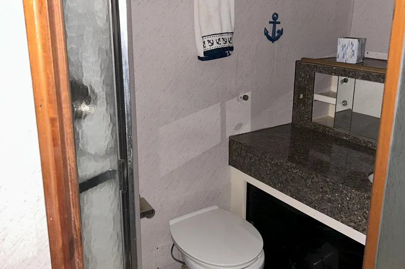 Slide: The Image of Bathroom interior of a 1977 Bertram 42 Motor Yacht with shower and granite countertop. - 49