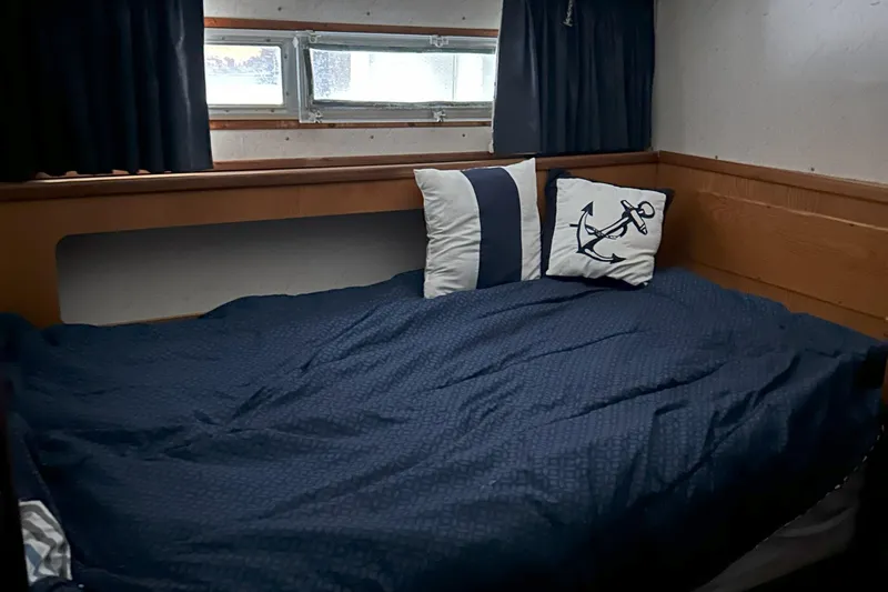 Slide: The Image of Cozy cabin interior of 1977 Bertram 42 Motor Yacht with nautical-themed pillows. - 5