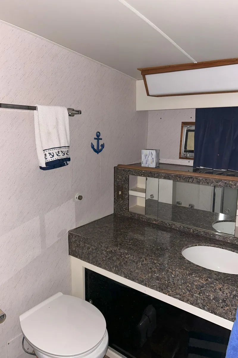 Slide: The Image of 1977 Bertram 42 Motor Yacht bathroom with granite countertop and nautical decor. - 50