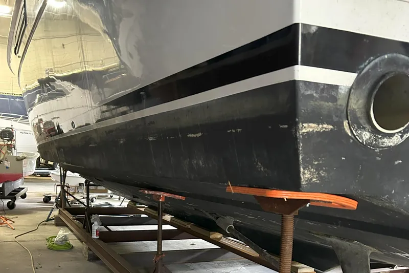 Slide: The Image of 1977 Bertram 42 Motor Yacht in a workshop, hull view with support stands. - 7