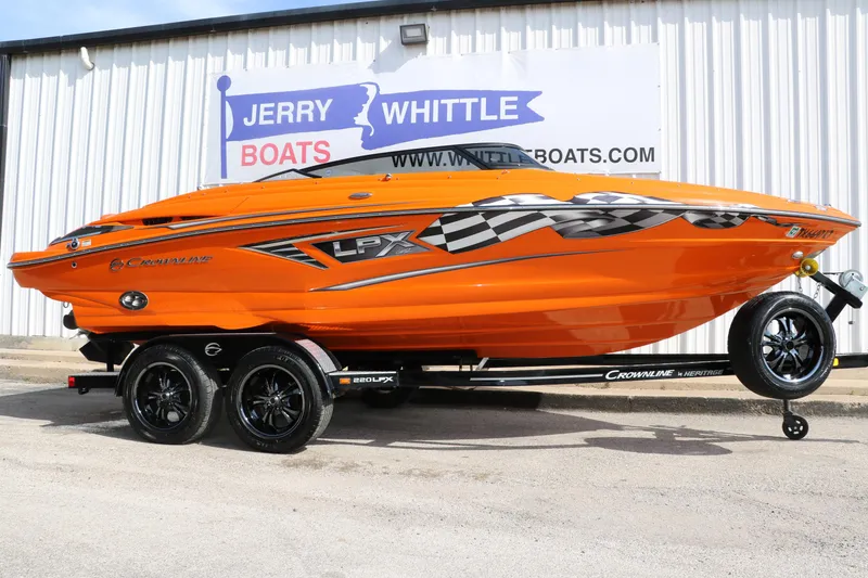 Slide: The Image of 2022 Crownline 220 SS LPX boat in vibrant orange on a trailer. - 1