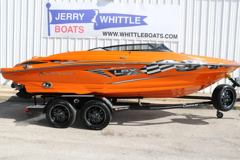 Slide: The Image of 2022 Crownline 220 SS LPX boat in vibrant orange on a trailer, displayed at Jerry Whittle Boats. - 11