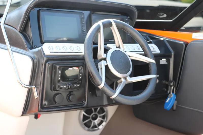 Slide: The Image of 2022 Crownline 220 SS LPX boat dashboard with steering wheel and control panel. - 22