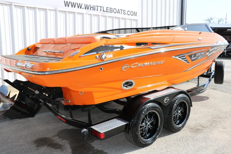 Slide: The Image of 2022 Crownline 220 SS LPX boat in vibrant orange on a trailer. - 3