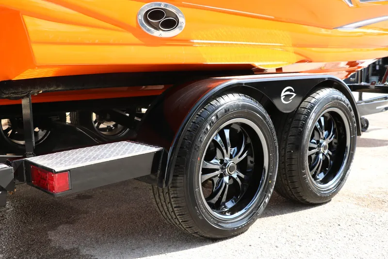 Slide: The Image of 2022 Crownline 220 SS LPX boat trailer with sleek black wheels and vibrant orange hull. - 39