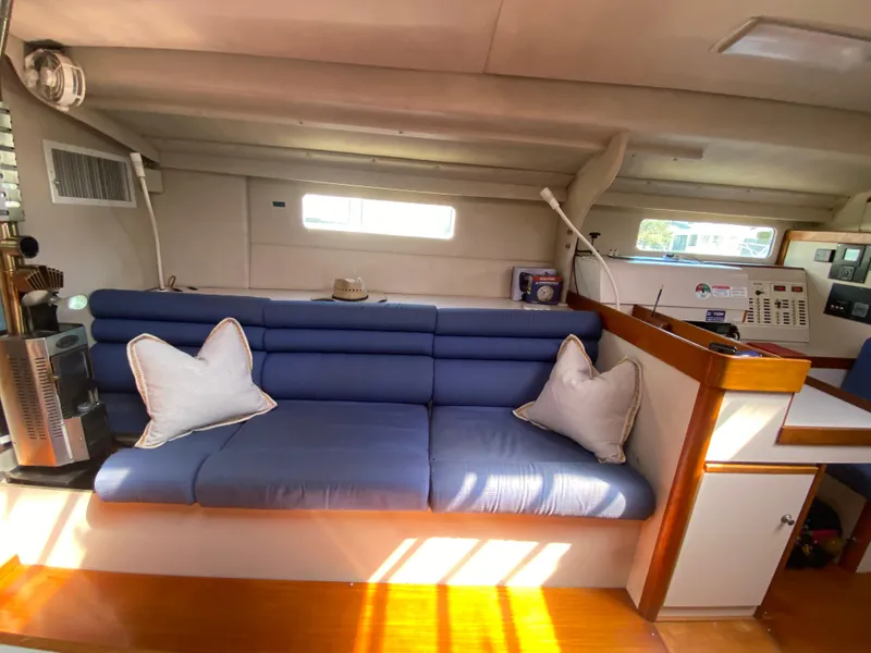Slide: The Image of Interior of a 1995 Sundeer 56 yacht with blue seating and white pillows. - 12