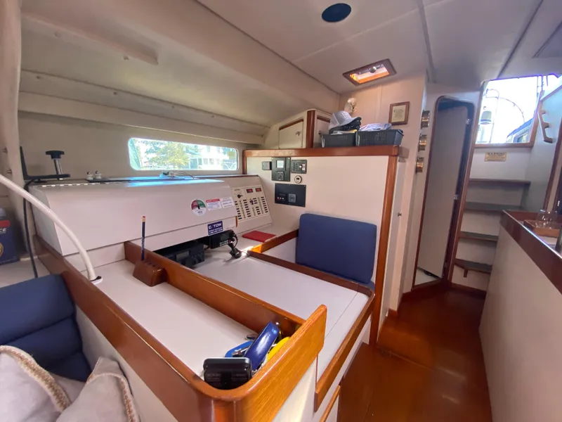 Slide: The Image of Interior of a 1995 Sundeer 56 yacht, featuring navigation station and seating area. - 13
