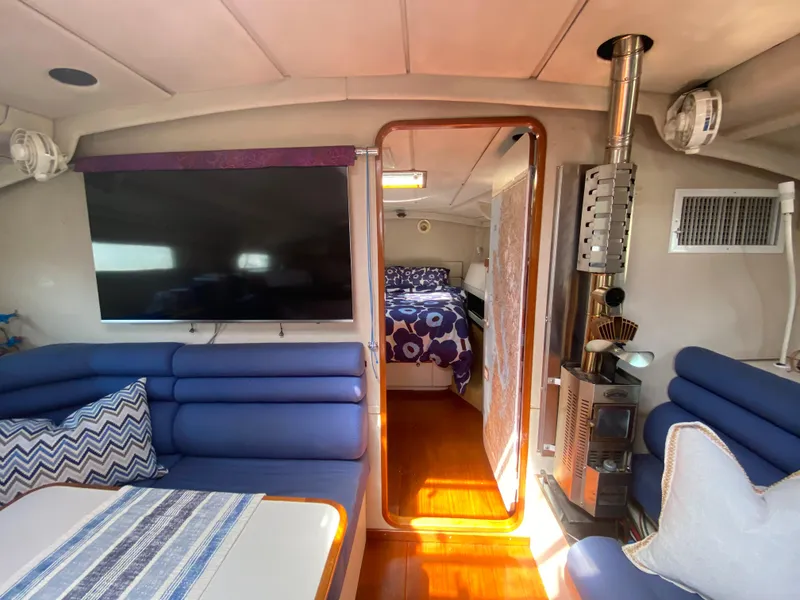 Slide: The Image of Cozy interior of 1995 Sundeer 56 yacht with blue seating, TV, and wood stove. - 15