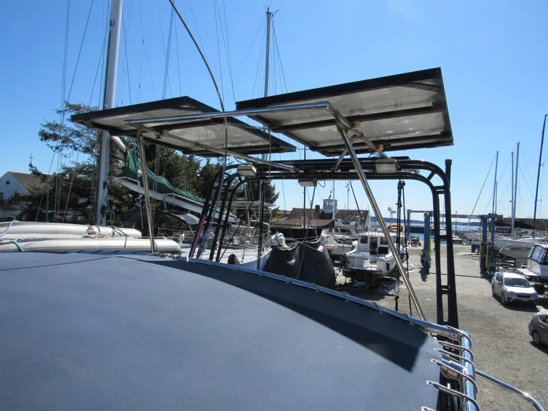Slide: The Image of Sundeer 56 sailboat with solar panels, docked in a marina, clear blue sky. - 38