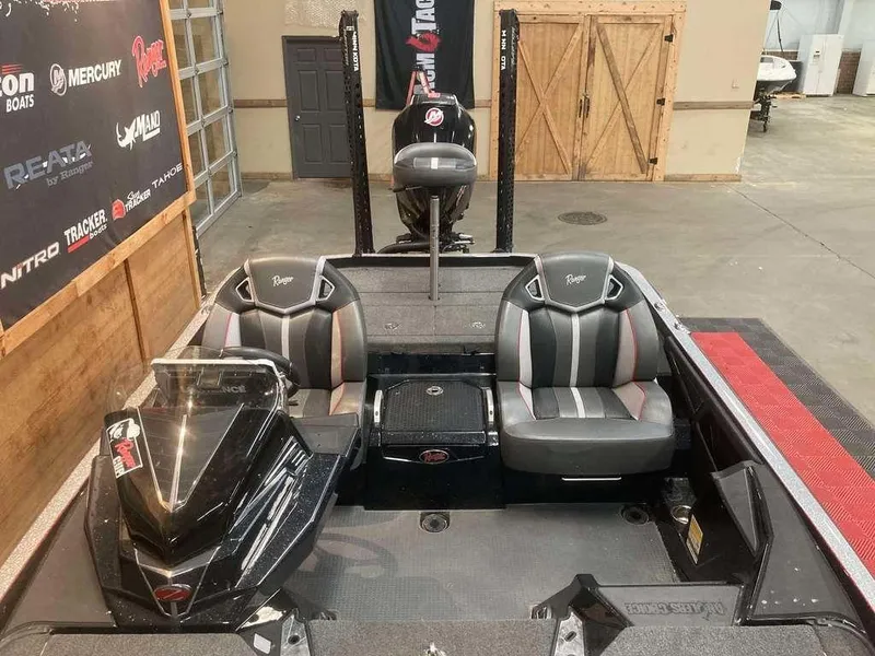 Slide: The Image of 2024 Ranger Z520R boat interior with dual seats and control console in a showroom. - 9
