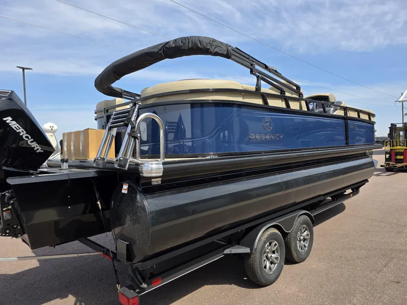 Slide: The Image of 2025 Regency 230 DL3 pontoon boat on trailer, featuring sleek design and Mercury engine. - 1