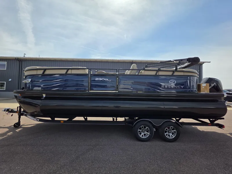 Slide: The Image of 2025 Regency 230 DL3 pontoon boat on trailer, parked outdoors. - 4