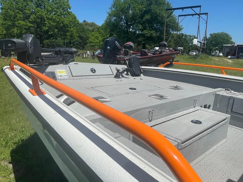 Slide: The Image of 2022 SeaArk ProCat 240 boat with orange railings, parked outdoors on grass. - 3