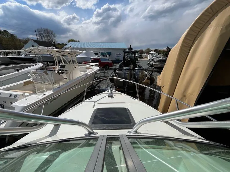 Slide: The Image of 2008 Sailfish 2360 WAC boat docked among other vessels under cloudy skies. - 10