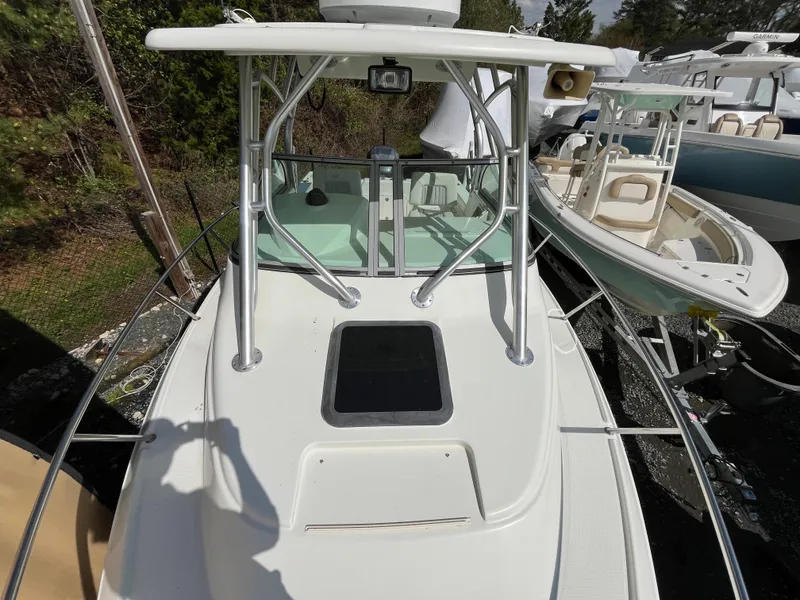 Slide: The Image of 2008 Sailfish 2360 WAC boat, white deck, docked, surrounded by other boats. - 12