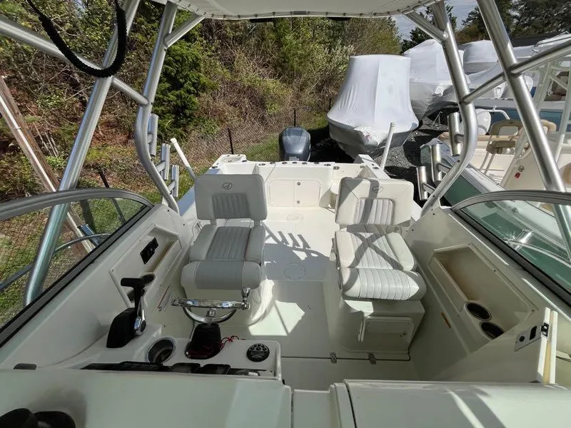 Slide: The Image of 2008 Sailfish 2360 WAC boat interior with seating and controls, docked outdoors. - 13