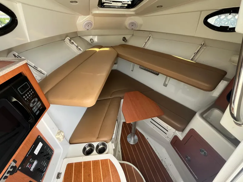 Slide: The Image of 2008 Sailfish 2360 WAC cabin interior with seating, table, and wood accents. - 17