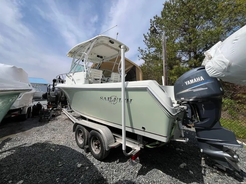 Slide: The Image of 2008 Sailfish 2360 WAC boat on trailer with Yamaha outboard motor, parked outdoors. - 2