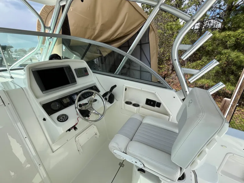 Slide: The Image of 2008 Sailfish 2360 WAC boat cockpit with steering wheel and control panel. - 8