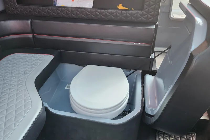 Slide: The Image of 2022 Axopar Brabus Shadow 900 ST interior with a compact marine toilet. - 17