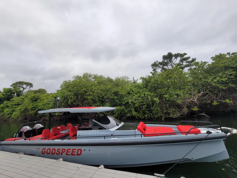 Slide: The Image of 2022 Axopar Brabus Shadow 900 ST boat docked near lush greenery. - 20