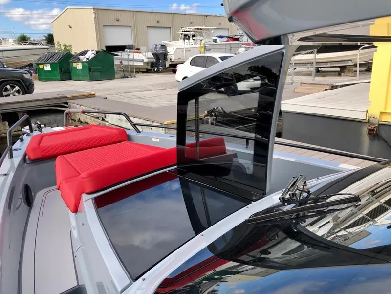 Slide: The Image of 2022 Axopar Brabus Shadow 900 ST with red seating, docked at a marina. - 6