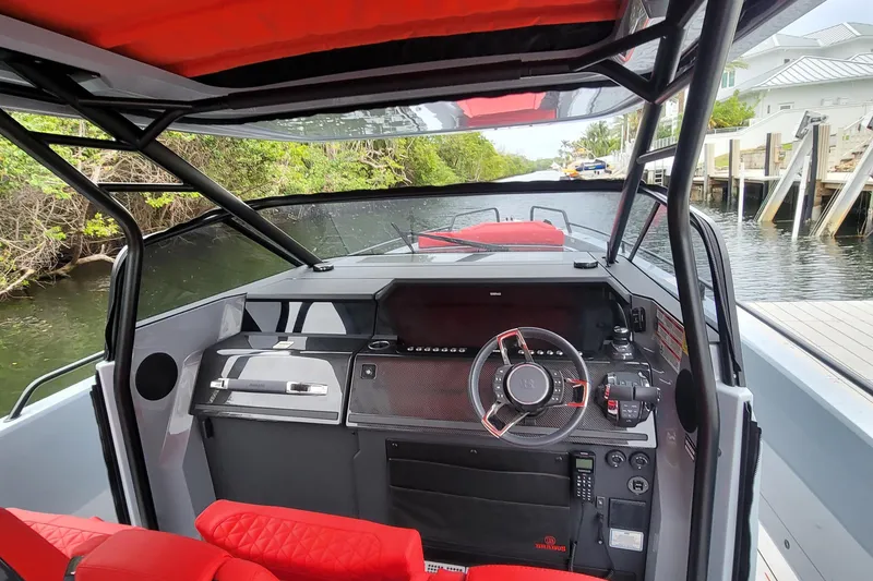Slide: The Image of 2022 Axopar Brabus Shadow 900 ST boat interior with red seating and modern dashboard. - 10