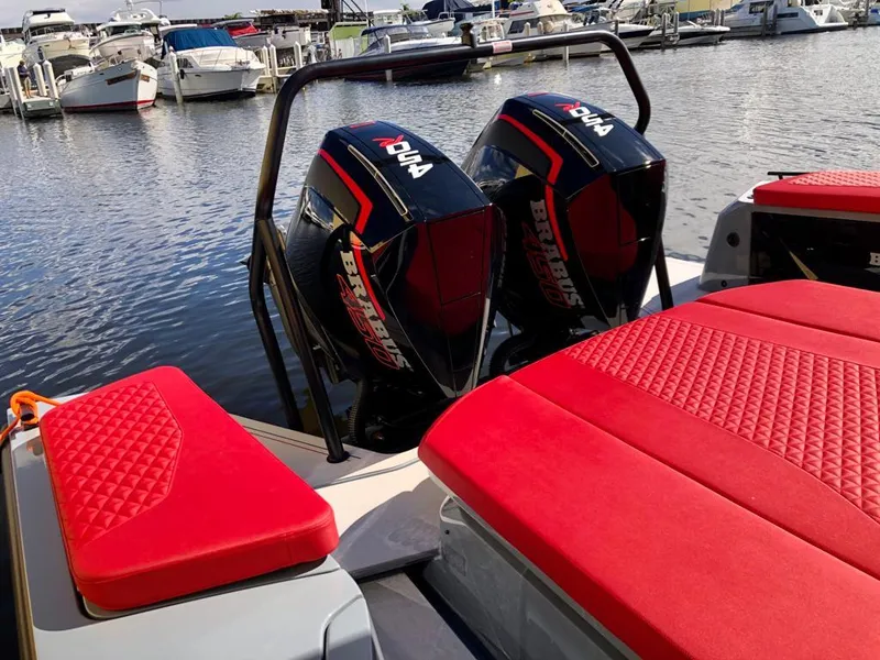 Slide: The Image of 2022 Axopar Brabus Shadow 900 ST with dual engines and red seating at a marina. - 19